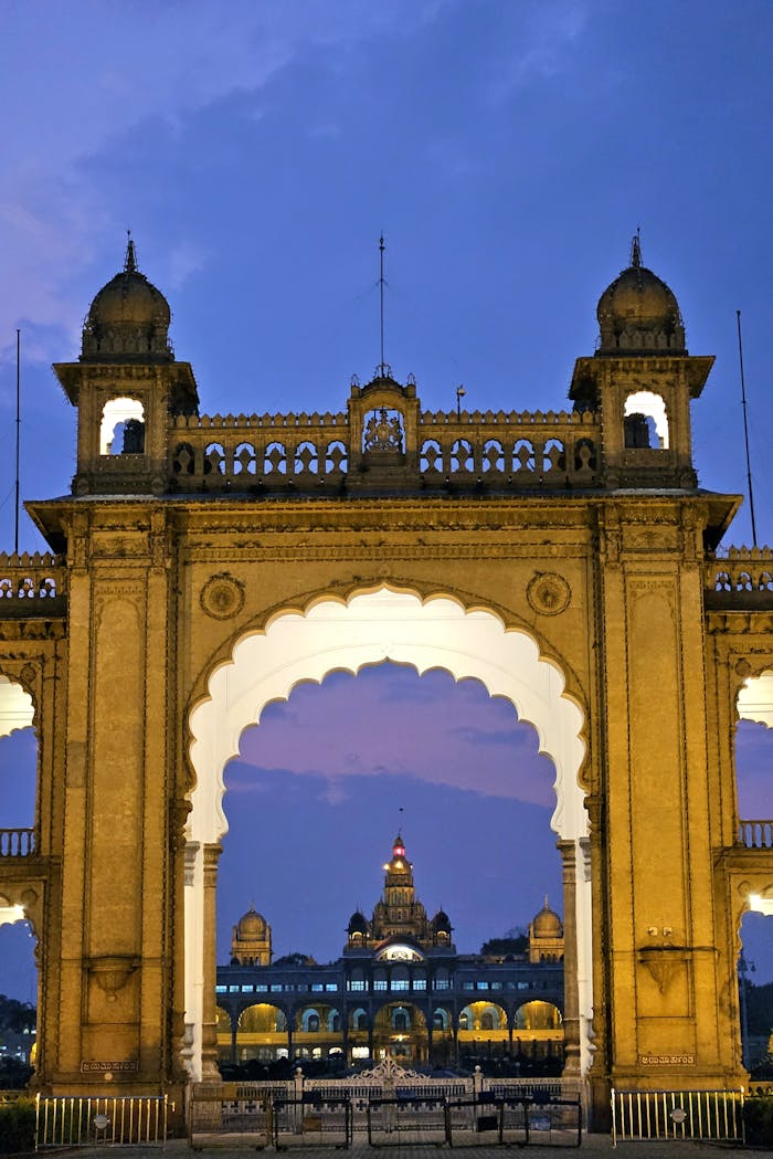 Beautiful view of the Mysore Palace through a decorative gate at dusk, highlighting its grandeur.